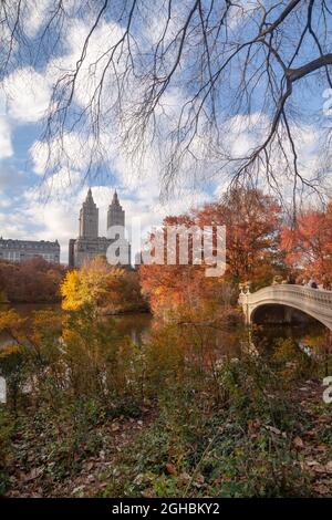 Central Park im Herbst mit Blick auf Bow Bridg und die Skyline der Wohnanlage auf der Upper Manhattan West Side. Bogenbrücke und Eldorado-Gebäude auf der Rückseite Stockfoto