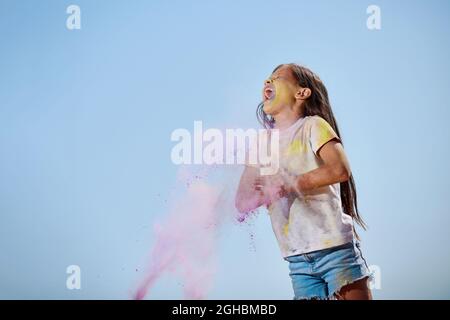 Glücklich kleines Kind Mädchen werfen helle Farben Stockfoto