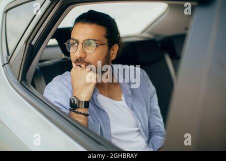 Araber sitzt im Auto und träumt während der Reise Stockfoto