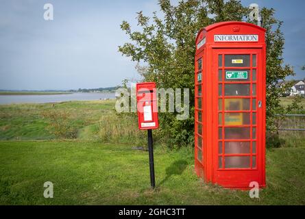 Alte Royal Mail Briefkasten und ein Notfall-Defibrillator in einer alten roten Telefonbox, Glencaple Village, Dumfries und Galloway, Schottland. Stockfoto