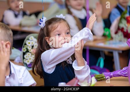 Die Erstklässler hebt ihre Hand in der Lektion, will eine Antwort geben. In der Schule ist der 1. September der Tag des Wissens. Moskau, Russland, 1. September, Stockfoto