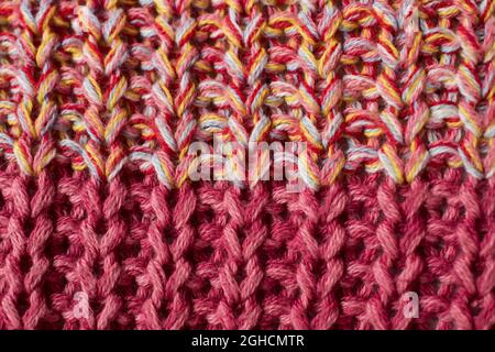 Nahaufnahme eines Pullovers aus rosa und gelb gestrickter Wolle Stockfoto