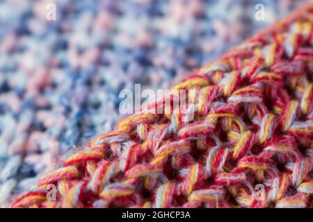 Nahaufnahme eines Pullovers aus rosa und gelb gestrickter Wolle Stockfoto