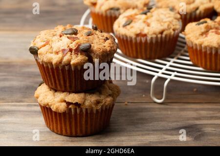 Kürbismuffins mit Krümel und Samen auf einem rustikalen Holztisch Stockfoto