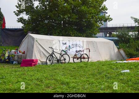 London, Großbritannien. September 2021. Während des DSEI-Protestes vor Excel London ist ein Zelt mit einem Banner des "People's Opposition Camp" zu sehen.Demonstranten haben vor dem Excel Center in East London einen Campingplatz eingerichtet, mit Plänen, die Waffenmesse Defence and Security Equipment International (DSEI), die am 14-17. September 2021 stattfindet, zu stören. Kredit: SOPA Images Limited/Alamy Live Nachrichten Stockfoto