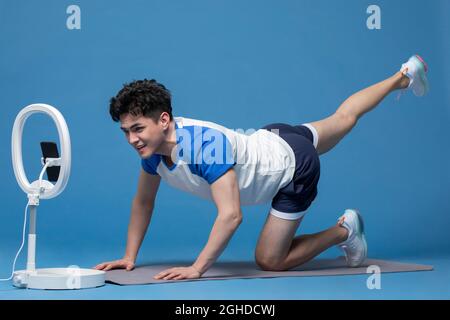 Fröhlicher junger Athlet beim Live-Webcast Stockfoto