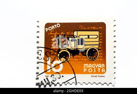 Eine alte ungarische Briefmarke, die ein Post-Retro-Auto zeigt, altes Auto, mit schriftlichen Worten Magyar Posta, Wert 10 Ungarischer Forint um 1987 isoliert Stockfoto