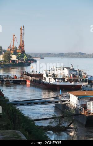 Hafen von Ruse, Donau, Bulgarien. Vertikales Foto mit Kräne und festfahrenden Schiffen Stockfoto