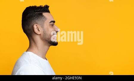 Profilportrait eines fröhlichen arabischen Mannes, der den Kopierraum betrachtet Stockfoto