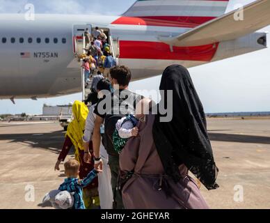 Sigonella, Italien. September 2021. Afghanische Flüchtlinge, die aus Kabul evakuiert wurden, bestiegen eine Boeing 777-Maschine von American Airlines von der Naval Air Station Sigonella am 4. September 2021 in Sigonella, Italien. Sigonella dient als Haltungszentrum und Evakuierungszentrum, um qualifizierte Flüchtlinge an festere Orte zu bringen. Kredit: MC2 Andrea Rumple/U.S. Navy/Alamy Live News Stockfoto