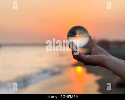 Wunderschöne Aussicht durch die Linse aus Kristallkugel bei Sonnenuntergang im Sommer. Stockfoto