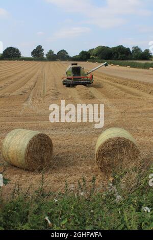 Mähdrescher auf einem Feld an einem heißen Sommertag im Juli auf einem Feld in West Yorkshire UK Stockfoto