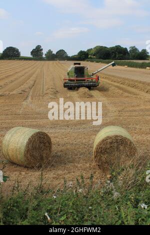 Mähdrescher auf einem Feld an einem heißen Sommertag im Juli auf einem Feld in West Yorkshire UK Stockfoto