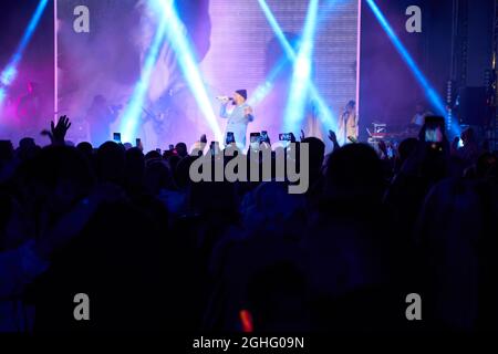 Menschenmenge im Club. Viele Leute beim Konzert. Silhouetten von Menschen auf dem Hintergrund der Bühne Stockfoto