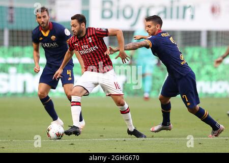 AC Mailands türkischer Mittelfeldspieler Hakan Calhanoglu nimmt den Ball als Roma-italienischer Mittelfeldspieler Lorenzo Pellegrini mit, ebenso WIE ROMA-italienischer Mittelfeldspieler Bryan Cristante während des Serie-A-Spiels bei Giuseppe Meazza in Mailand. Bilddatum: 28. Juni 2020. Bildnachweis sollte lauten: Jonathan Moscrop/Sportimage via PA Images Stockfoto