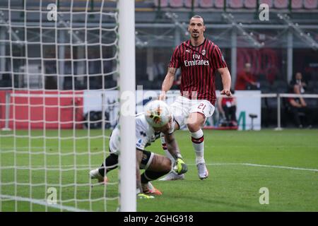 Der schwedische Stürmer Zlatan Ibrahimovic vom AC Mailand sieht sich an, als Teamkollege Alessio Romagnoli an dem italienischen Torwart Luigi Sepe von Parma Calcio vorbeifliegt, um der Mannschaft während des Spiels der Serie A bei Giuseppe Meazza, Mailand, eine 2-1-Führung zu geben. Bilddatum: 15. Juli 2020. Bildnachweis sollte lauten: Jonathan Moscrop/Sportimage via PA Images Stockfoto