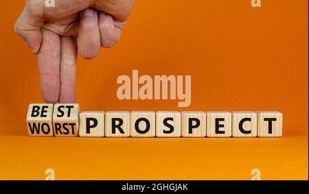 Symbol für den besten oder schlechtesten Interessenten. Der Geschäftsmann dreht Holzwürfel und ändert die Worte „schlechtester Ausblick“ in „bester Ausblick“. Schöner orangefarbener Hintergrund. Busi Stockfoto