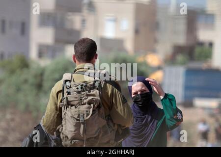 Jenin, Palästina. September 2021. Israelische Soldaten sahen, wie sie in der Nähe der israelischen Trennmauer mit Palästinensern sprachen.sechs palästinensische Gefangene entkamen am Montag aus dem Gefängnis in Israel, was zu einer weit verbreiteten Menschenjagd führte, sagten die israelischen Behörden. Die Polizei sagte in einer Erklärung, dass die äußerst seltene Flucht über Nacht im Gilboa Gefängnis stattfand, einem Gefängnis mit maximaler Sicherheit für palästinensische Gefangene in Nordisraelisch. Kredit: SOPA Images Limited/Alamy Live Nachrichten Stockfoto