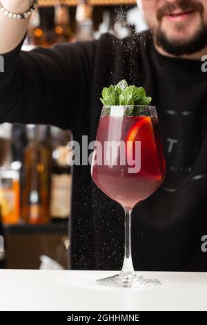 Der Barkeeper macht Red Sangria im italienischen Restaurant. Sangria-Cocktail mit Rotwein an der Bar verschwommen Stockfoto