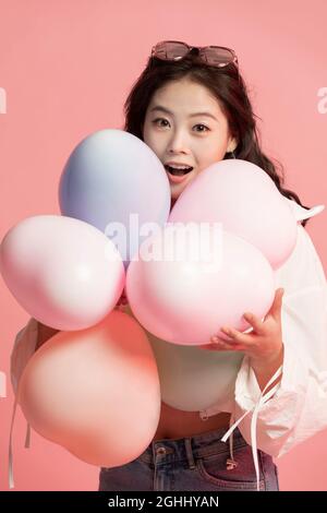 Studio-Aufnahme von niedlichen jungen Frau mit Ballons Stockfoto