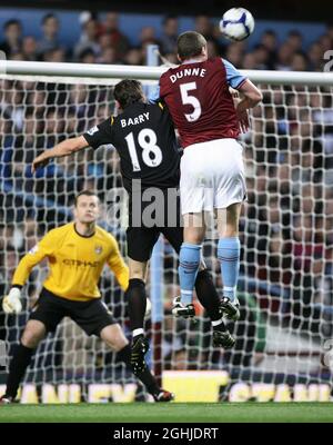 Richard Dunne überspringt Gareth Barry, um beim Spiel in der Barclays Premier League zwischen Aston Villa und Manchester City im Villa Park in Birmingham das Eröffnungstor von Villa zu erzielen. Stockfoto