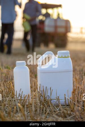 Nahaufnahme von Kunststoffbehältern mit Pestiziden und Chemikalien zum Pflanzenschutz im Feld Stockfoto