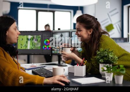 Videofilmmontage mit moderner Software, die Ideen mit Kollegen im Startup Studio Office teilt. Kollegen, die über den kreativen Prozess in der Postproduktionsagentur sprechen Stockfoto