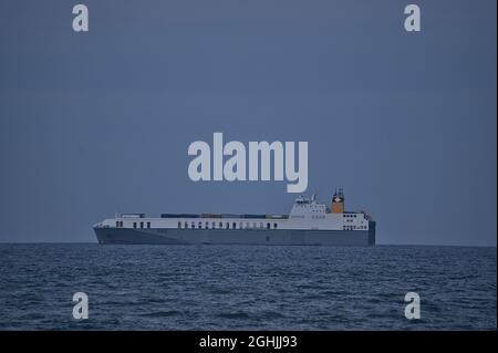 Wunderschöne Abendansicht des Frachtschiffes in der Irischen See vom West Pier des Hafens von Dun Laoghaire, Dublin, Irland. Weicher und selektiver Fokus. Minimal Stockfoto