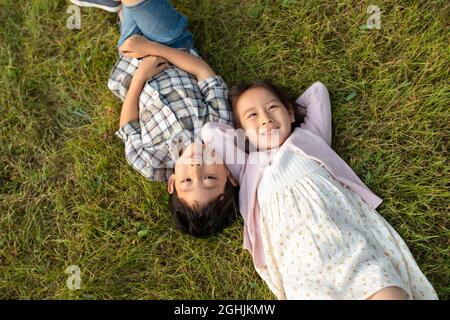 Glückliche Kinder auf dem Rasen liegend Stockfoto