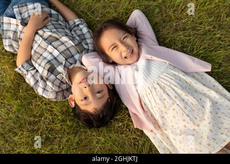 Glückliche Kinder auf dem Rasen liegend Stockfoto