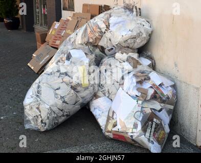 Abgeflachte Kartons und Papiersäcke warten auf die Wiederverwertung in einer Straße in Victioria, British Columbia, Kanada, auf der Insel Vancouver. Stockfoto