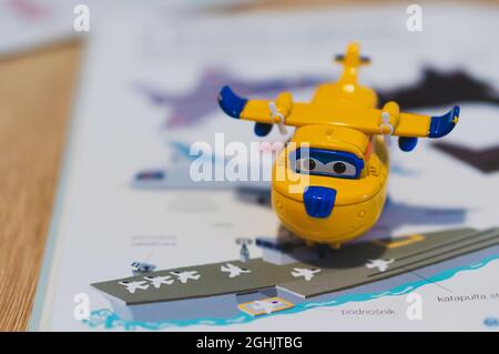 POZNAN, POLEN - 21. Oktober 2018: Ein gelbes Super Wings Donnie-Spielzeug-Modellflugzeug auf einem offenen Buch Stockfoto
