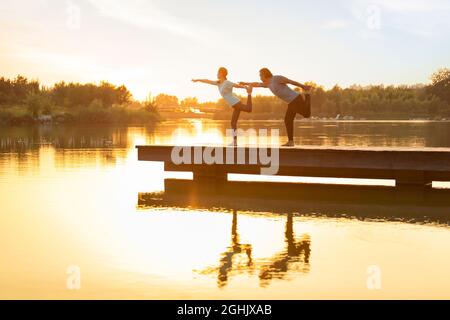 Glückliches reifes Paar, das Yoga im Park macht Stockfoto