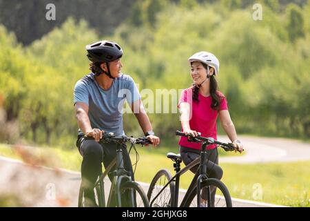 Glückliches reifes Paar, das Fahrräder im Park fährt Stockfoto