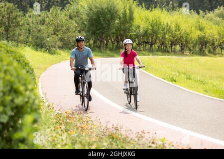 Glückliches reifes Paar, das Fahrräder im Park fährt Stockfoto