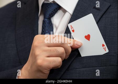 ACE-Karte in der Hand eines Geschäftsmannes in einem Anzug. Stockfoto