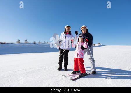 Junge Eltern lehren Tochter Skifahren Stockfoto
