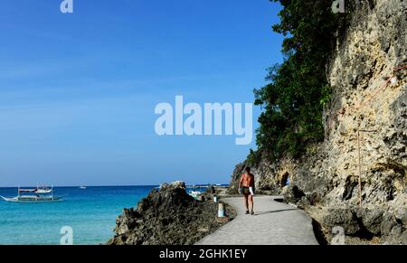 Ein Mann, der an den Klippen von Boracay auf den Philippinen entlang läuft Stockfoto