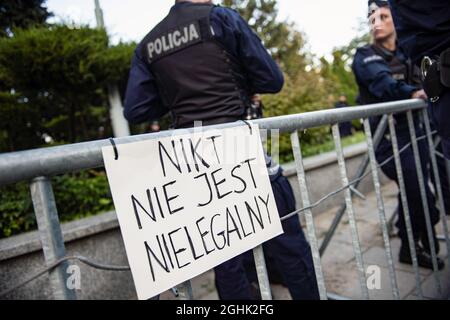 Warschau, Polen. September 2021. Während des Protestes wird ein Plakat mit der Aufschrift "Niemand ist illegal" am Polizeizaun aufgehängt.das polnische Parlament hat heute Abend den Ausnahmezustand in zwei an Weißrussland angrenzenden Regionen offiziell genehmigt - der erste Befehl seiner Art seit den kommunistischen Tagen Polens. Viele der wichtigsten Oppositionsparteien Polens haben den Ausnahmezustand kritisiert und argumentiert, dass es sich um eine Überreaktion handelt, die die bürgerlichen Freiheiten eindämmerte. Kredit: SOPA Images Limited/Alamy Live Nachrichten Stockfoto