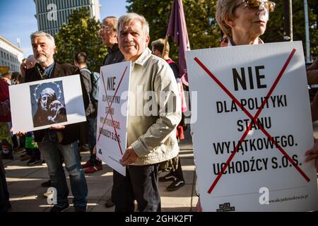 Warschau, Polen. September 2021. Aktivist hält während des Protestes Plakate mit der Aufschrift "Nein zum Ausnahmezustand, s.o.s. Flüchtlinge".das polnische Parlament hat heute Abend formell den Ausnahmezustand in zwei Grenzregionen zu Belarus genehmigt - die erste Ordnung dieser Art seit den kommunistischen Tagen Polens. Viele der wichtigsten Oppositionsparteien Polens haben den Ausnahmezustand kritisiert und argumentiert, dass es sich um eine Überreaktion handelt, die die bürgerlichen Freiheiten eindämmerte. Kredit: SOPA Images Limited/Alamy Live Nachrichten Stockfoto