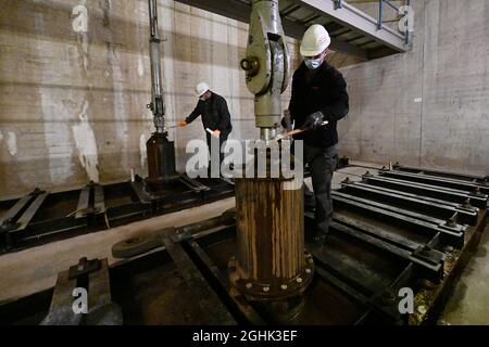 Edertal, Deutschland. September 2021. Mitarbeiter der Staudammaufsicht stehen bei der Inspektion der Pumpspeicherkraftwerke Waldeck am Edersee im Einlaufbau des oberen Beckens des Pumpspeicherkraftwerks Waldeck 2 an einem Fallschutz. Die Staudammaufsicht muss die Staudämme in regelmäßigen Abständen inspizieren. (An dpa 'auf dem Damm mit dem Staumeister') Quelle: Swen Pförtner/dpa/Alamy Live News Stockfoto