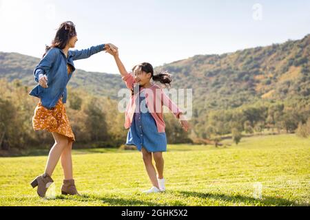 Glückliche Mutter und Tochter spielen auf der Wiese Stockfoto