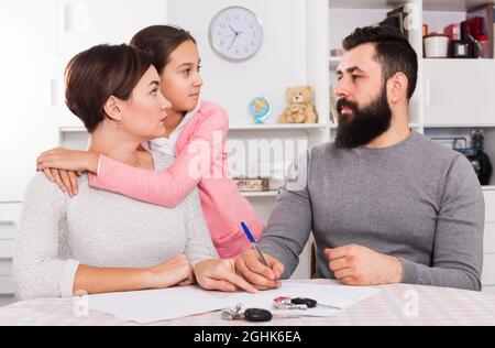 Eltern unterschreiben Scheidungspapiere Stockfoto