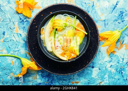 Suppe mit Reisnudeln und Knödeln in Kürbisblüten.flach legen Stockfoto