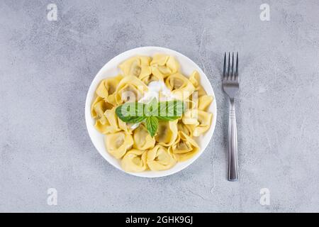Hausgemachte vegetarische italienische Tortelloni mit dekoriert mit frischem Basilikum auf einem Teller. Italienische Küche Stockfoto