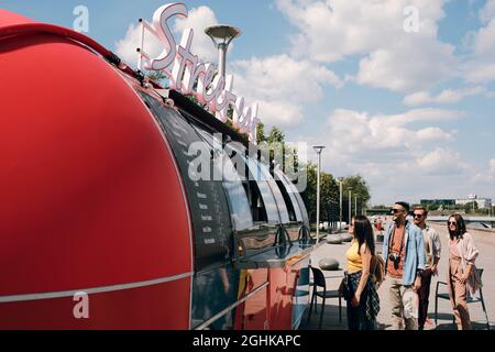 Eine Gruppe junger Kunden, die am Sommertag beim Straßenessen auf der Speisekarte stehen Stockfoto