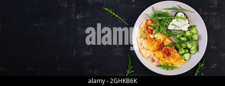 Frühstück. Omelette mit Tomaten, Käse und Salat auf weißem Teller. Frittata: italienisches Omelett. Draufsicht, Banner, flaches Lay Stockfoto