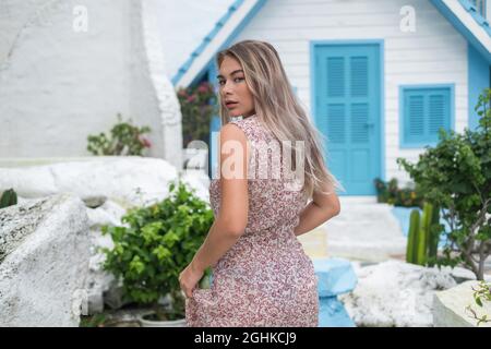 Porträt einer attraktiven Frau mit gesunder Haut und blondem langen Haar beim Gehen, direkt in die Kamera schauend. Gesichtsausdrücke Konzept. Stockfoto