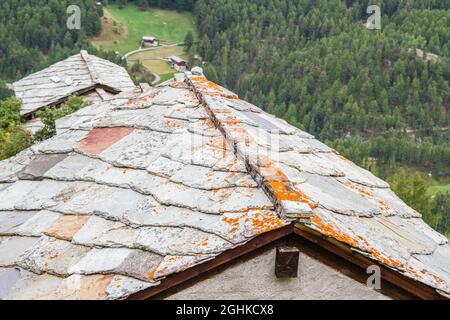 Dach von traditionellen Holzbauten mit Schiefersteinen im Kanton Wallis, Schweiz, Zermatt Stockfoto