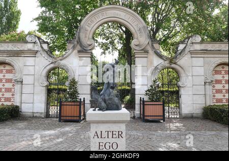 Die Skulptur „Alter Ego“ des Bildhauers Arnaud Kasper und der steinerne Eingang, der vom Jugendstilarchitekten Eugene Petit entworfen wurde, bei der âÂ€Â˜Cimetiere des ChiensâÂ€Â™ in Asnieres-sur-seine am Stadtrand von Paris, Frankreich am 2021. Mai.der Pariser âÂ€Â˜Friedhof der Hunde und andere häusliche AnimalsâÂ€Â™ soll der älteste öffentliche Tierfriedhof der Welt sein. Le âÂ€Â˜Cimetiere des ChiensâÂ€Â™ ist ein langer, enger Friedhof mit attraktiv gestalteten Anlagen, die Blick auf die seine. Die ordentlich angelegten Reihen von Gräbern umfassen Grabsteine und andere Denkmäler aus dem späten 19. Jahrhundert bis in die Gegenwart, viele wi Stockfoto